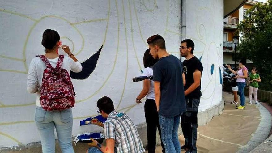 Voluntarios caldenses trabajando en el mural colectivo. // I.A.