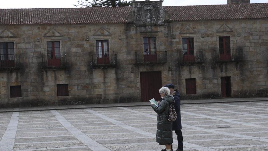 Una pareja observa un plano, sobre la una de la tarde de ayer, en la plaza de Fefiñáns. | Noé Parga
