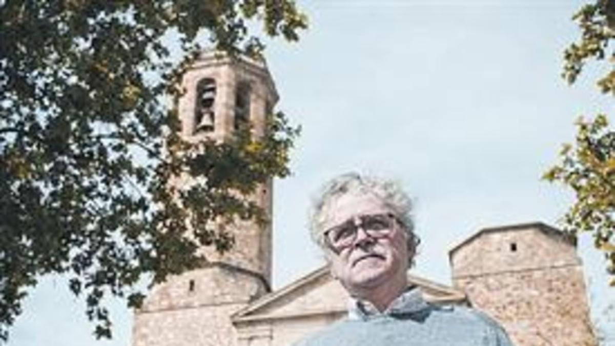 Jaume Gras, en la plaza de Sarrià, delante de la iglesia, con su libro.