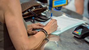 Archivo - Una persona rellena unos documentos tras solicitar el voto por correo