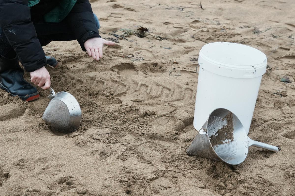 Un voluntario recoge pellets en la playa de La Arena, en Muskiz, Vizcaya.