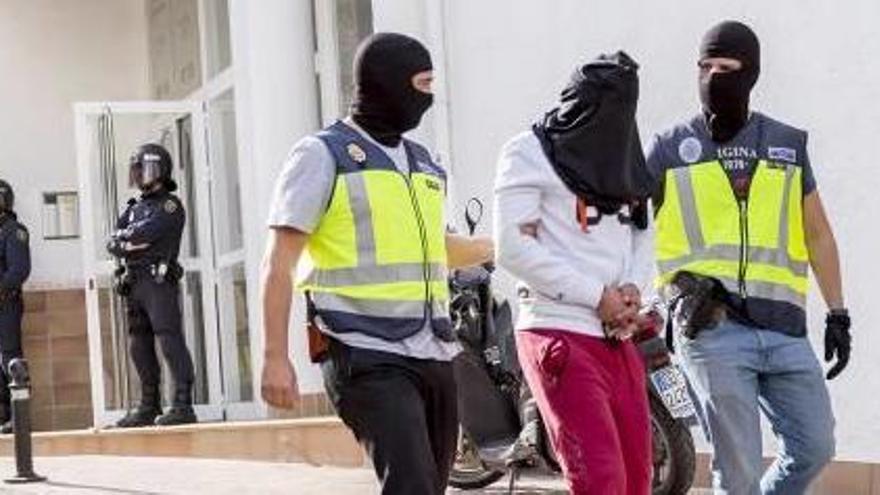 Dos policías trasladan al detenido en Altea tras el registro de la casa de su novia donde fue apresado.