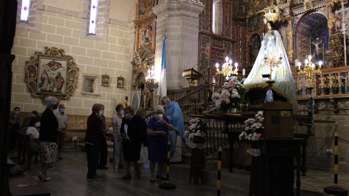 Momento de la eucaristía. Frente al altar, entronizada, la Virgen de los Remedios.