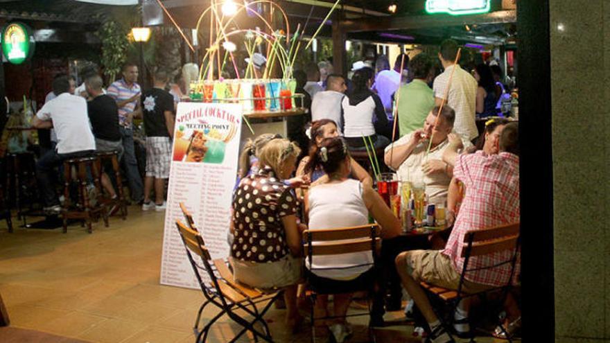 Un grup de turistes que beu alcohol en galledes, a la riera de Lloret.