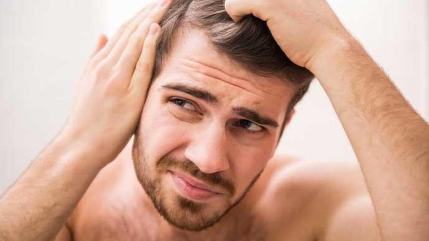 Un hombre preocupado por la pérdida de pelo.