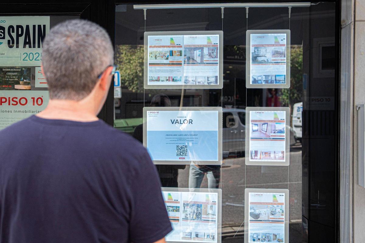 Una persona observa el escaparate de una inmobiliaria.