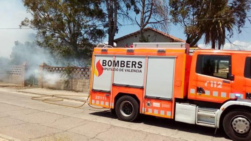 Incendio de matorrales junto a una casa abandonada