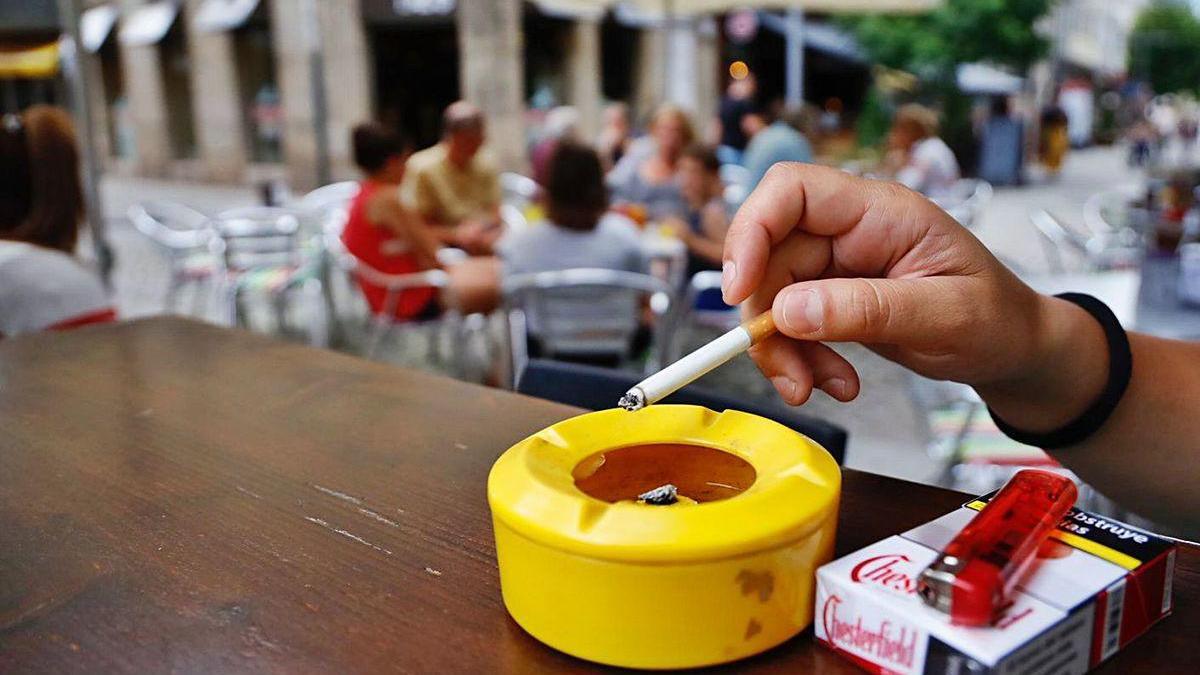 Una persona fuma un cigarrillo en la terraza de un local antes de la pandemia.