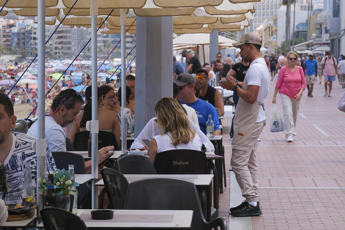 Un camarero atiende las mesas en el Paseo de Las Canteras, en Las Palmas de Gran Canaria.