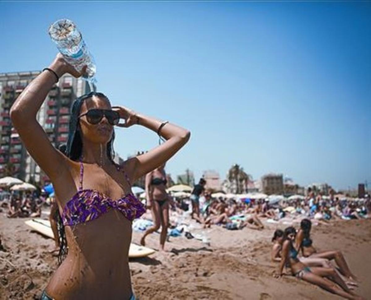 Una noia es refresca a la platja de la Barceloneta, ahir. Una noia es refresca a la platja de la Barceloneta, ahir.