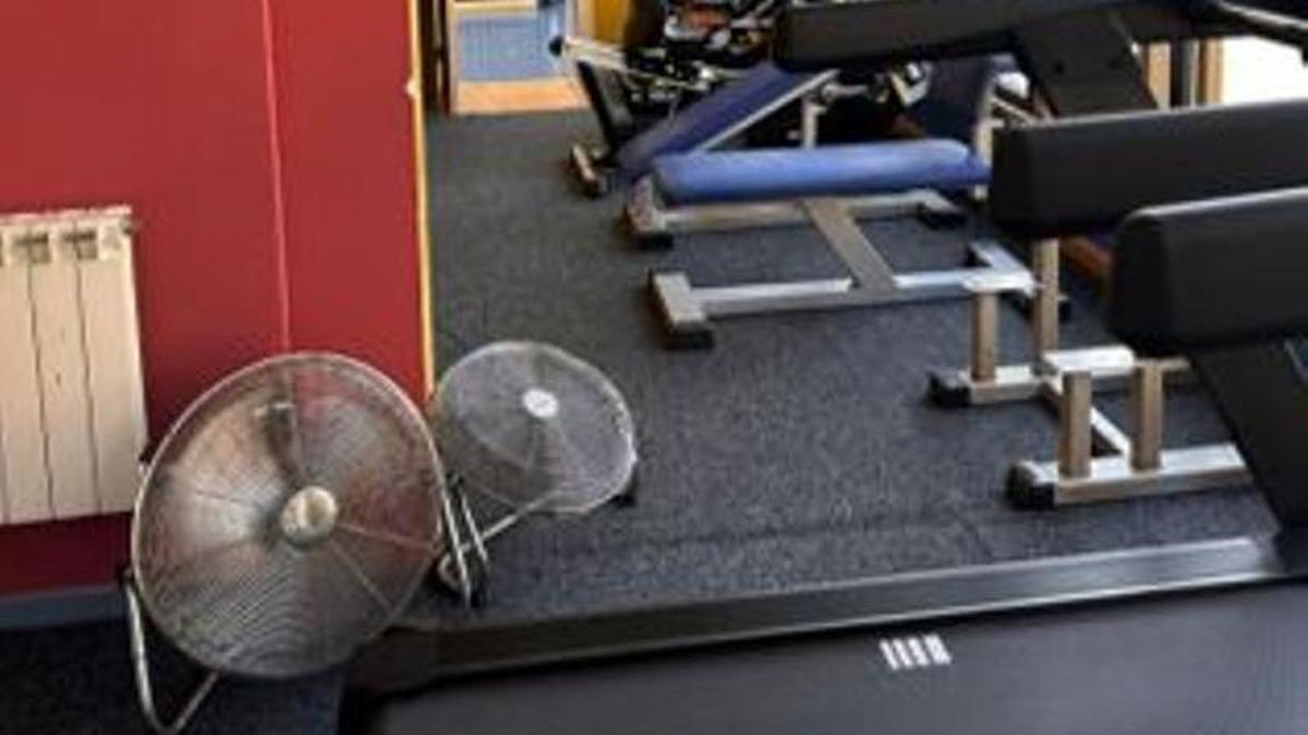 Sala de musculación del polideportivo de Cabañaquinta, con dos ventiladores colocados.