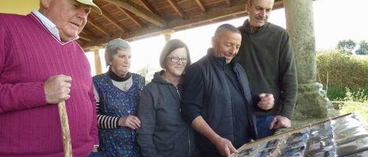 Indalecio García, Felisa Llera, Pilar Suárez, Toni Nava y Florín Suárez revisan las fotos de la última reconstrucción de la capilla.