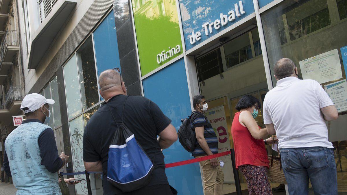 Personas en paro hacen cola frente a una oficina del SEPE en Barcelona para ser atendidos.