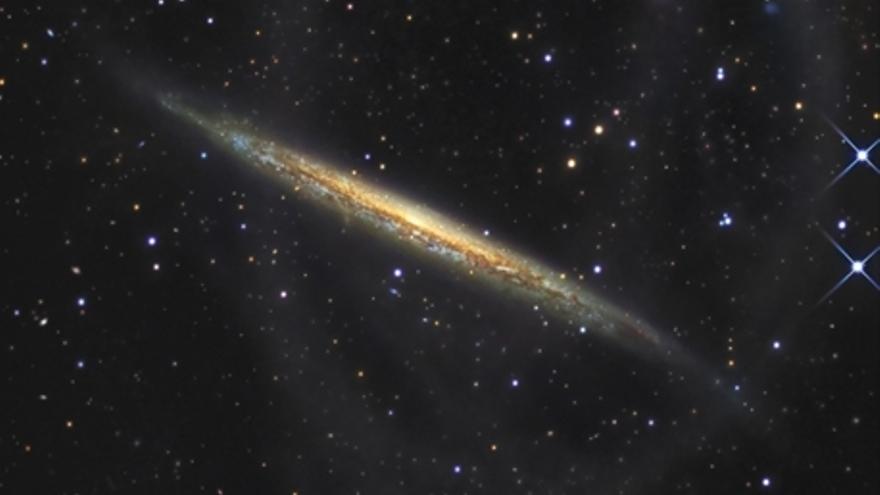 La imagen de NGC 4013 revela un nuevo perfil de la galaxia: una tenue y enorme estructura en bucle se extiende más de 80.000 años luz desde su centro (arriba y hacia la izquierda) 
R. Jay Gabany
