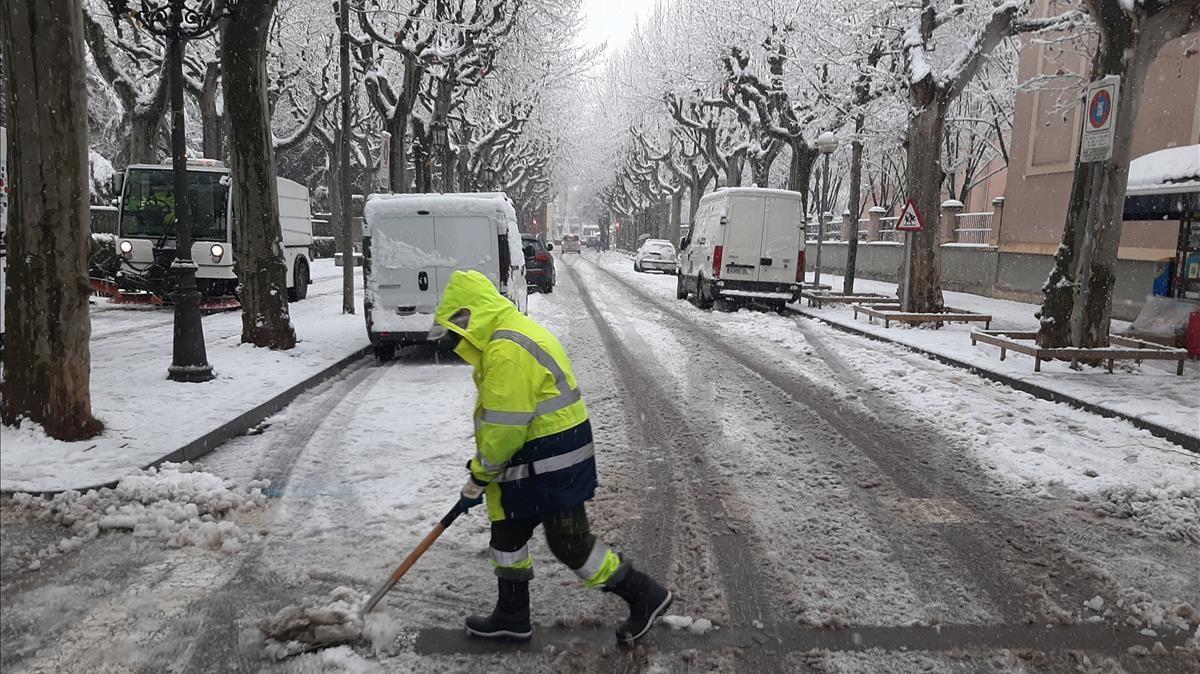 La tormenta Filomena deja blanco Olot, en la foto un operario saca la nieve de una céntrica calle de la ciudad