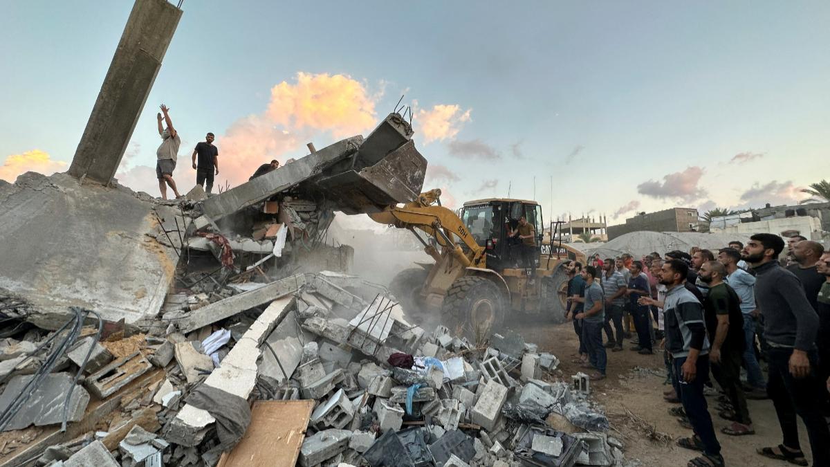Los palestinos trabajan para retirar los escombros mientras buscan víctimas bajo los escombros de una casa destruida por los ataques israelíes, en el centro de la Franja de Gaza.