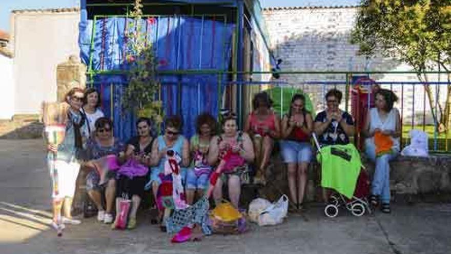 Un grupo de mujeres se entretiene haciendo labores de calceta durante los festejos de Tábara.