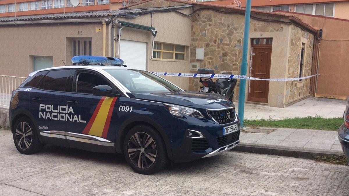 Un coche del 091 delante de la casa, acordonada, con una motocicleta aparcada a la puerta.