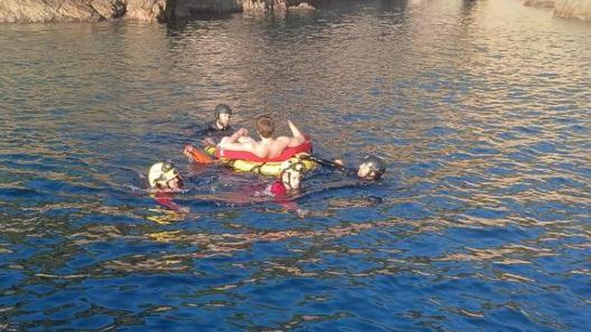 El jove durant el rescat, amb el sistema de flotació i camí a l'embarcació dels Mossos.