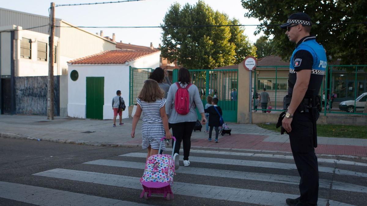 Un policía regula el paso de cebra de la entrada del colegio Alejandro Casona. | L.O.Z.