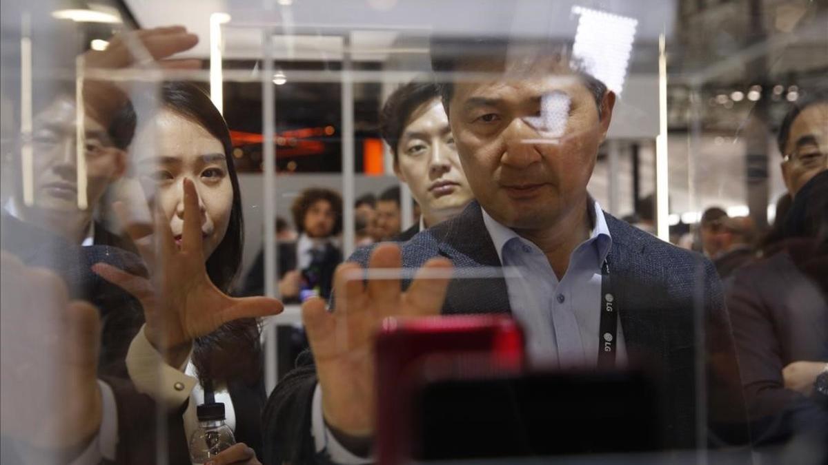 Visitantes del Mobile World Congress miran el LG8 Thin