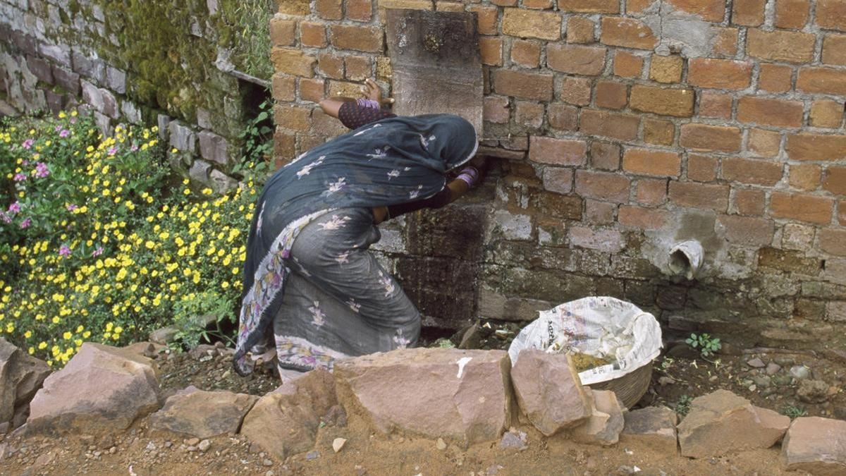 Una mujer de la casta dalit limpia una letrina en Bhopal, en 1997.