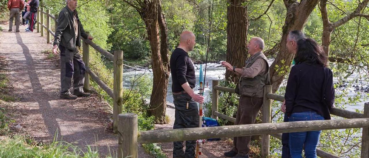 Ante la falta de capturas, los aficionados se reúnen en animadas tertulias a la orilla del río Narcea.