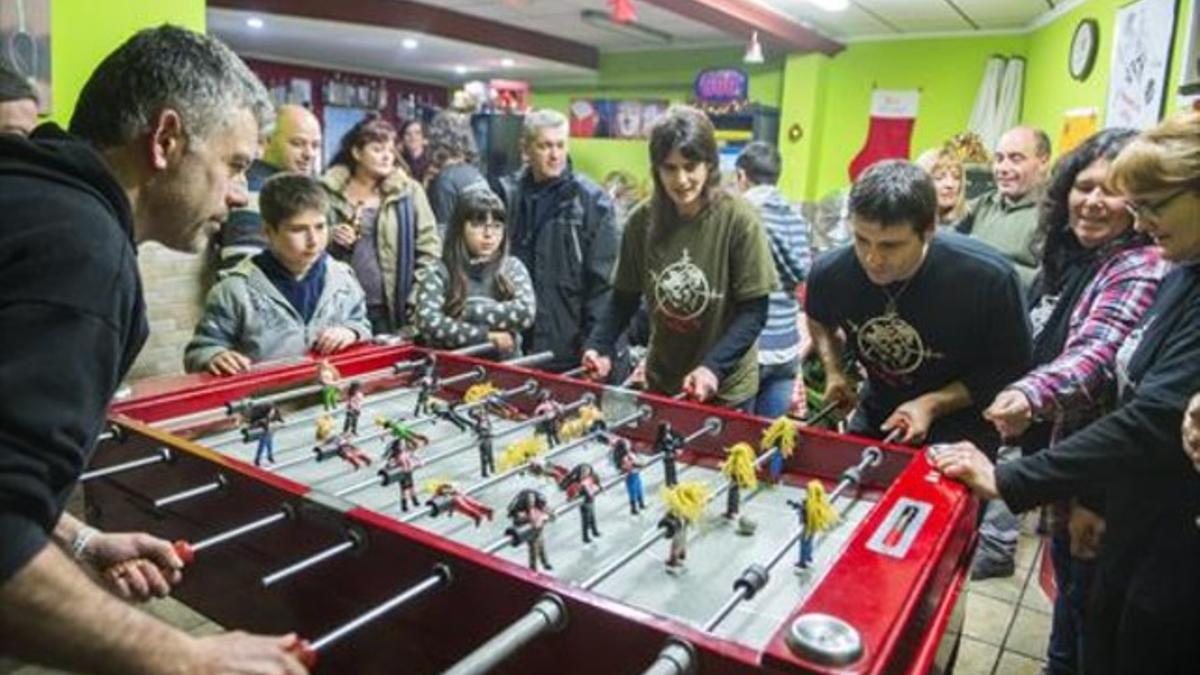 Habituales del bar El Jardí de Ciutat Meridiana, con el futbolín tuneado en el que los jugadores son músicos heavies.