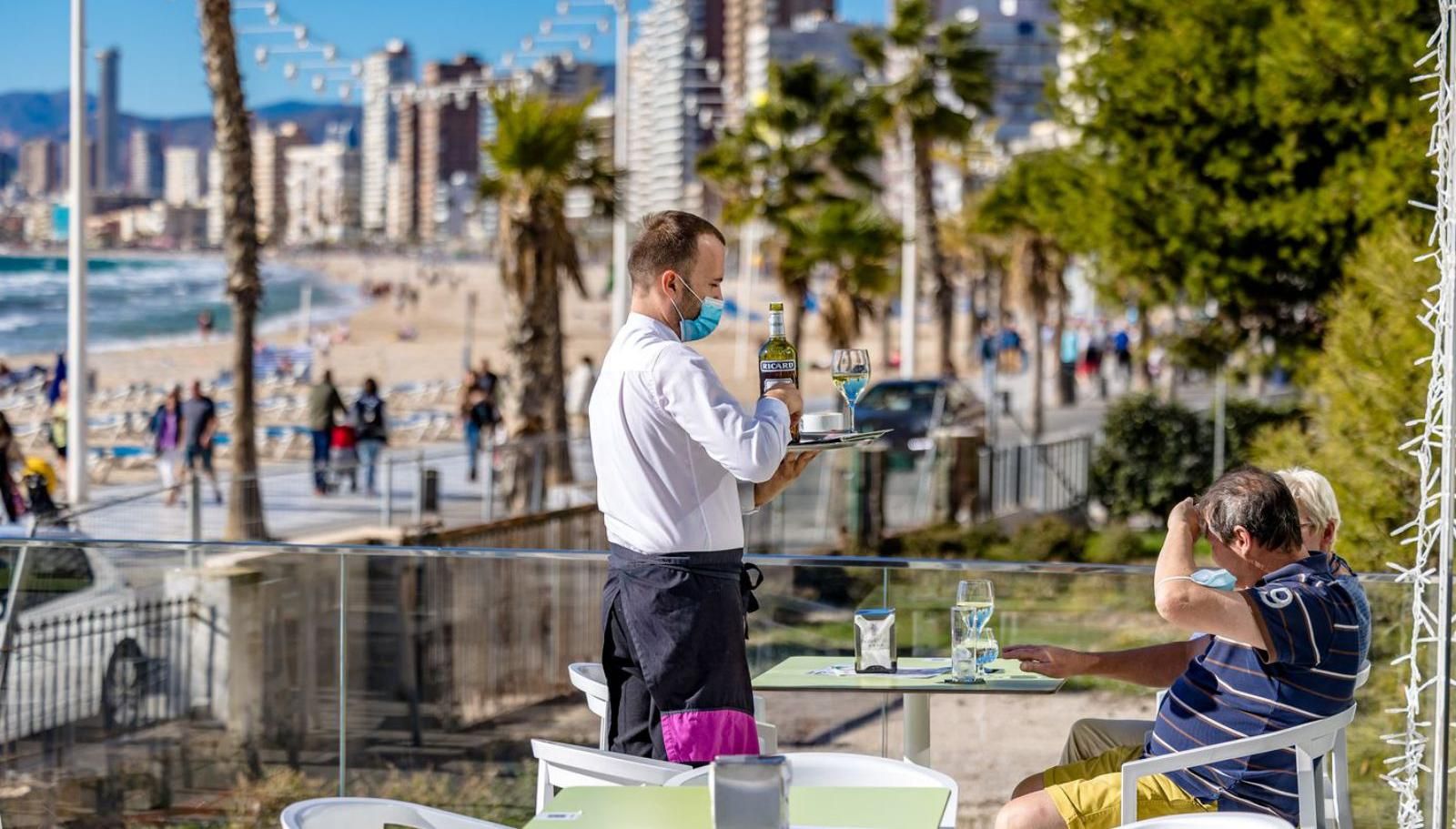 Un camarero atiende la terraza de un hotel de Benidorm, que espera «renacer» en marzo.  | DAVID REVENGA