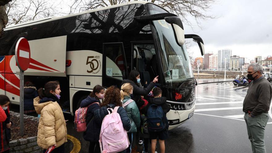 Alumnos del colegio Santo Ángel cogiendo el autobús a la salida del centro, ayer. | Juan Plaza