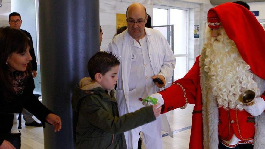 Papá Noel entrega un obsequio a un niño en el hospital