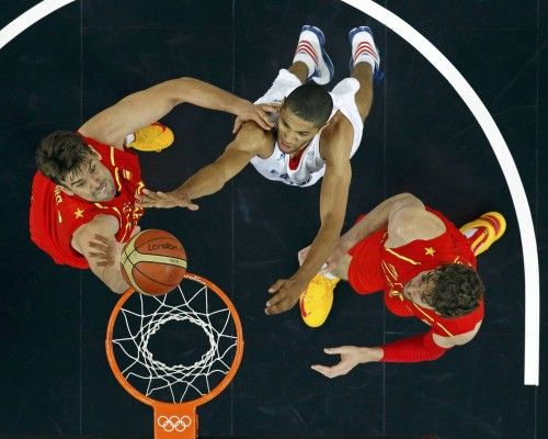 France's Batum reaches for the rebound with Spain's Gasol and Gasol during their men's quarterfinal basketball match at the North Greenwich Arena in London during the London 2012 Olympic Games