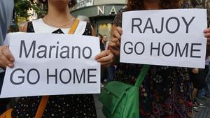 Dos manifestants demanen la dimissió de Rajoy davant de la seu del PP a Madrid aquest dimarts.