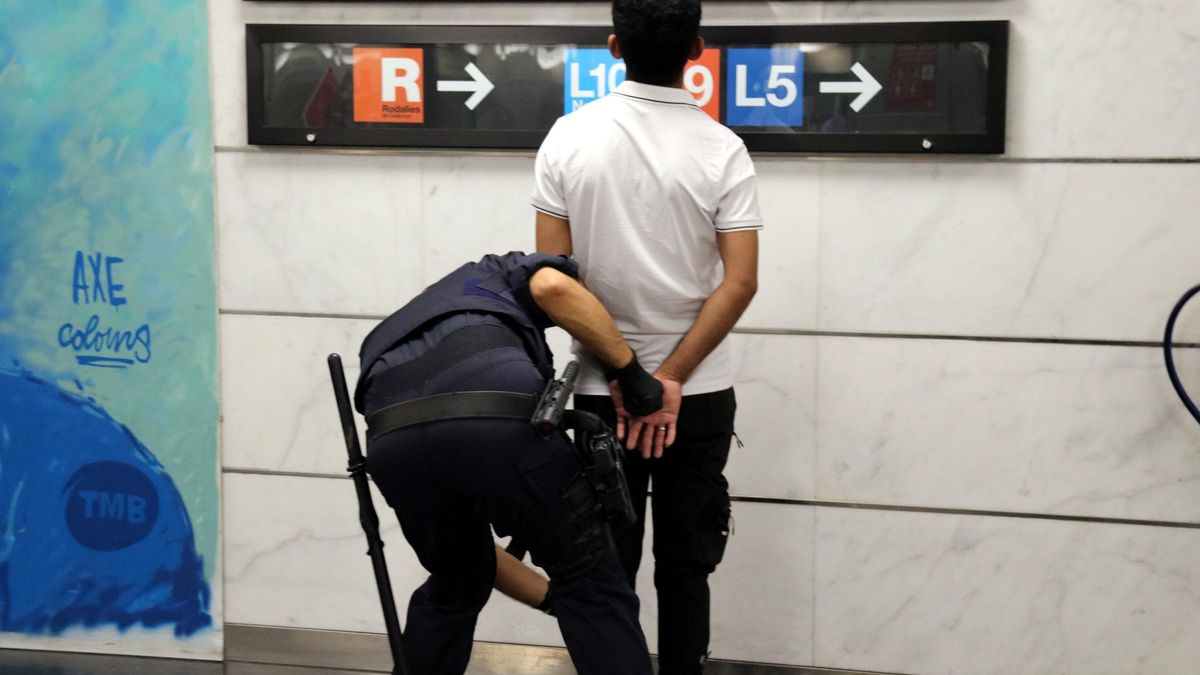 Un agent dels Mossos escorcollant un home a l'estació de la Sagrera