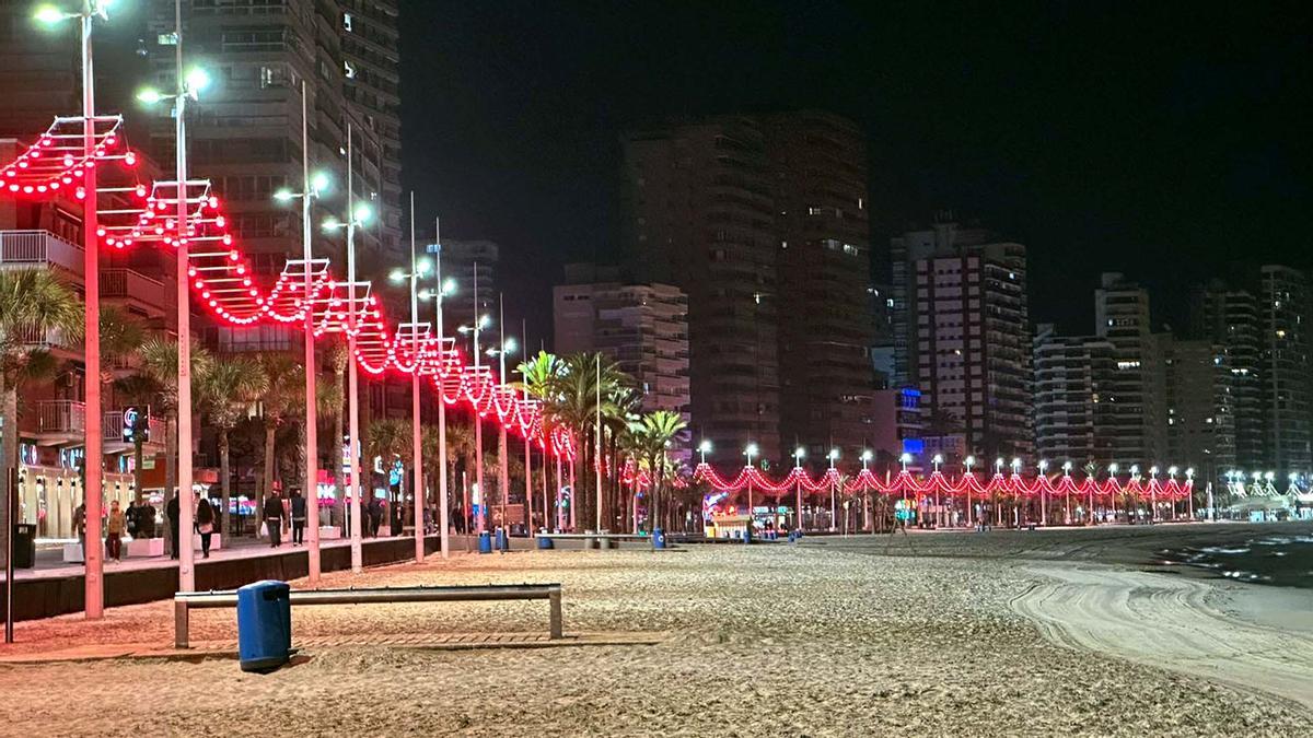 La playa de Levante iluminada en rojo.