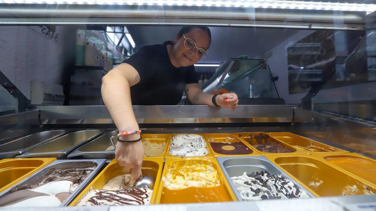 Una empleada sirve uno de los sabores de helado que ofrece David Rico.