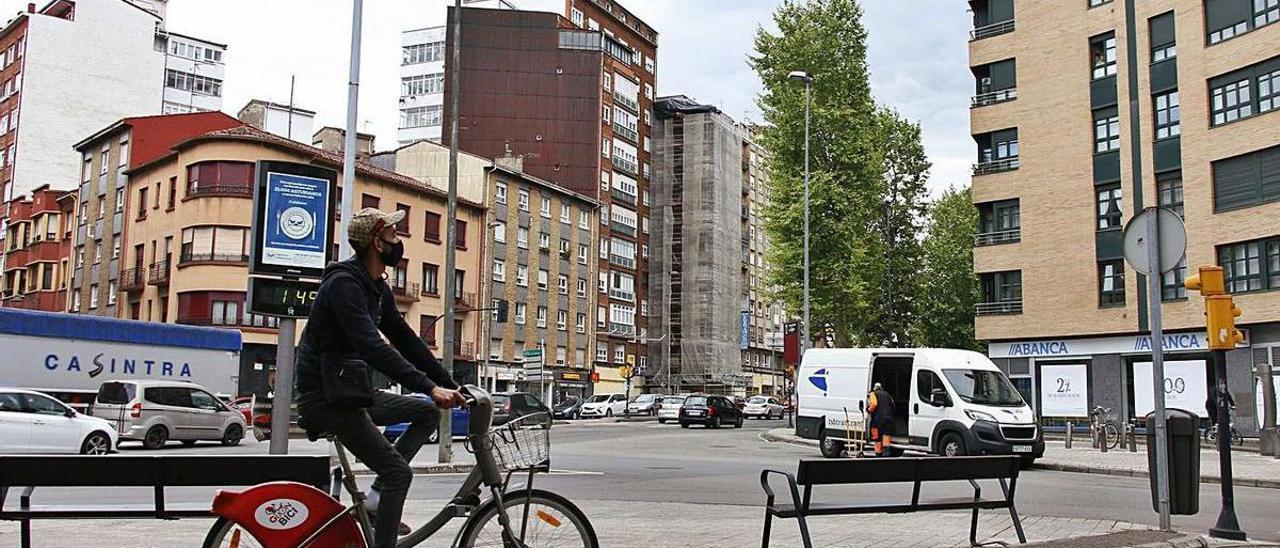 Un ciclista usa el carril bici a la altura de Cuatro Caminos, con una vista del tráfico de vehículos particulares y camiones que pasan por la zona. | Pablo Solares |  FIRMA