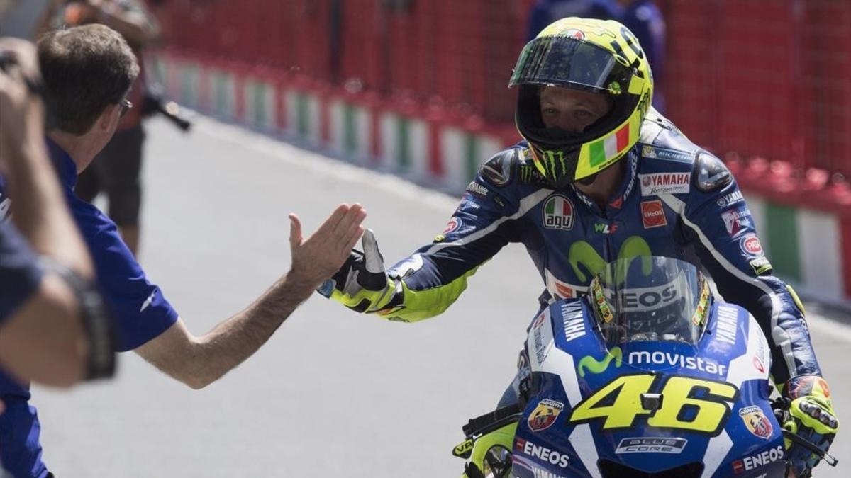 Valentino Rossi es felicitado por Lin Jarvis, jefe de Yamaha, tras conseguir la 'pole position' en Mugello con la ayuda de Maverick Viñales.