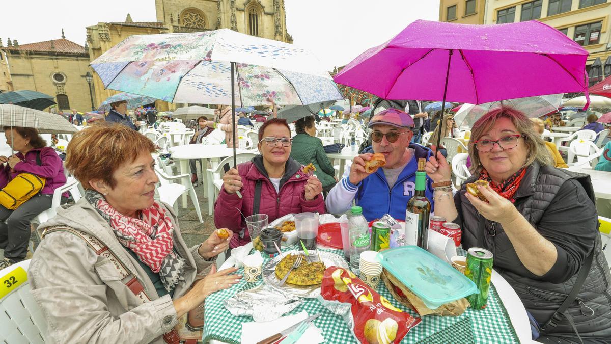 El Martes de Campo de Oviedo aguanta el chaparrón con ganas, mucho paraguas y participación popular pese al cambio de ubicación