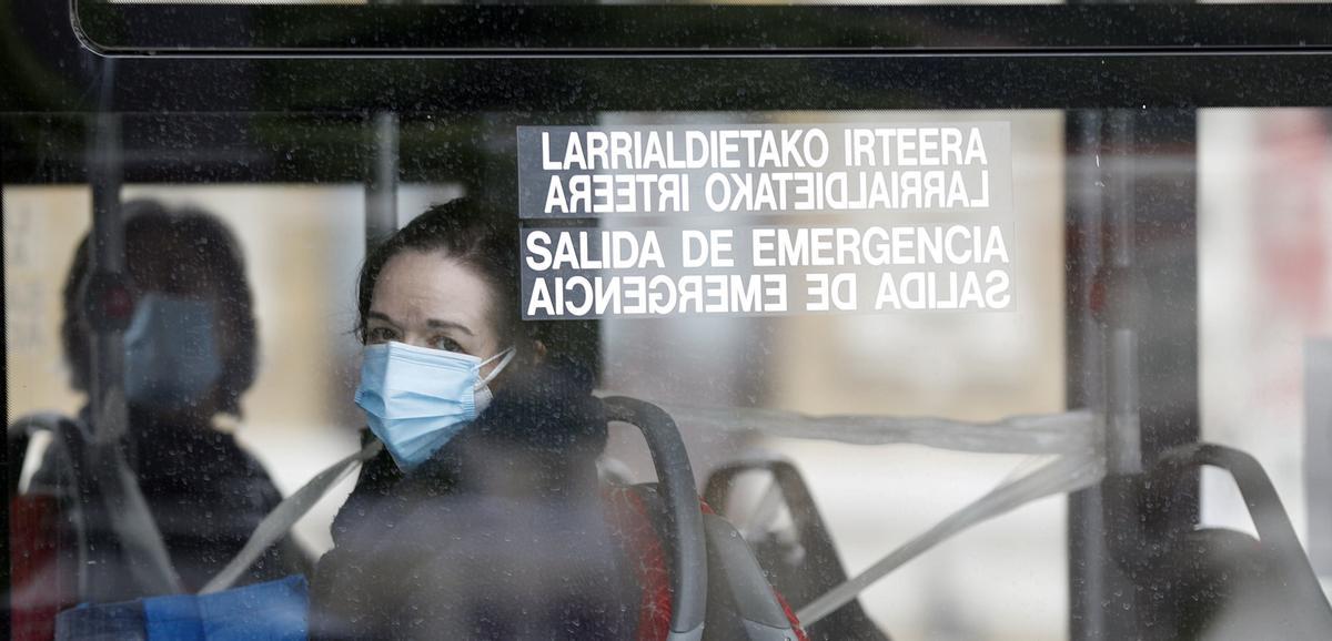 Una persona con mascarilla viaja en autobús.