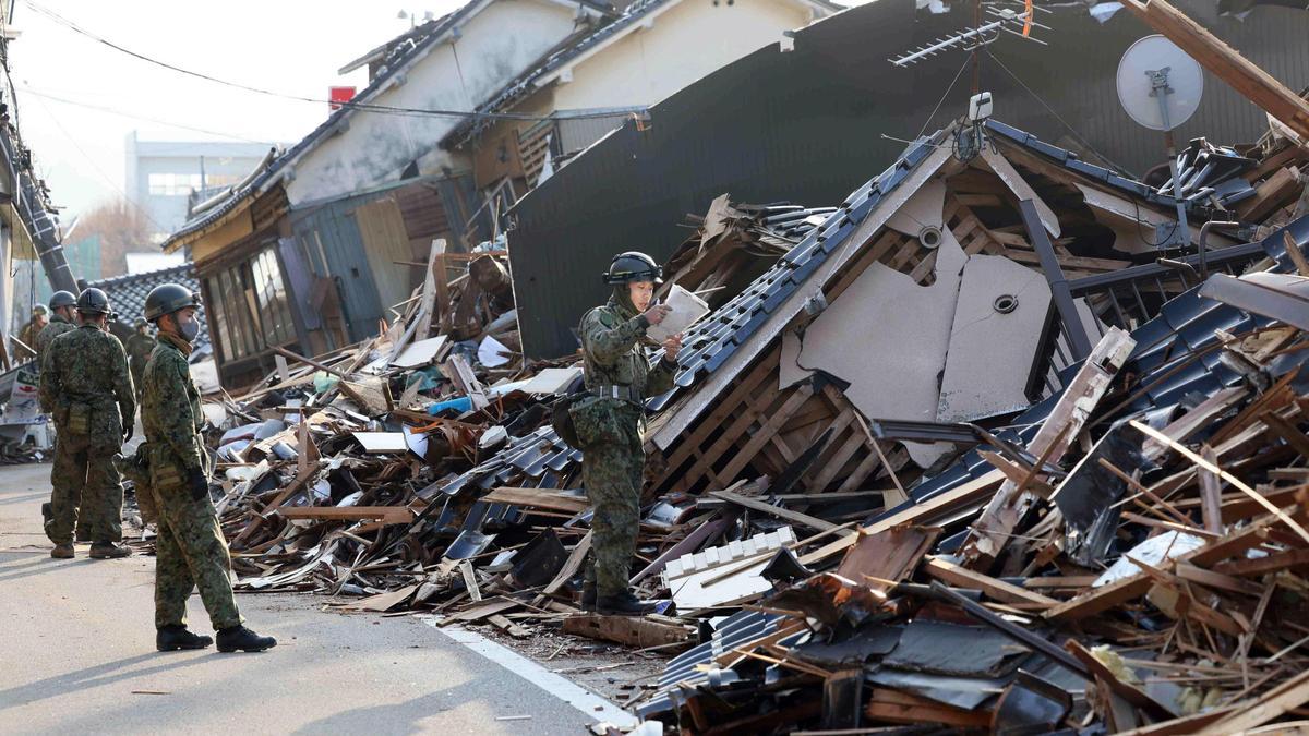 Trabajadores del servicio de emergencias japonés buscan a supervivientes tras el terremoto que sacudió Wajima a principios de este año