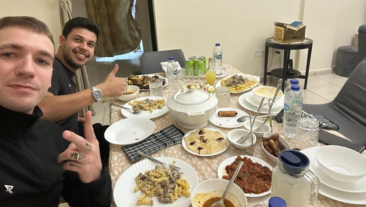 Pedro e Ismael, murcianos en Dubái ante una mesa con abundante comida este martes.