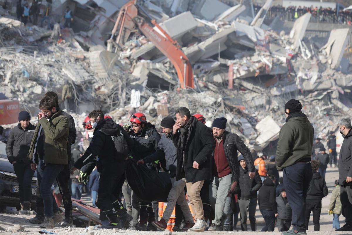 Personas rodeadas de escombros en uno de los lugares del terremoto, en Turquia
