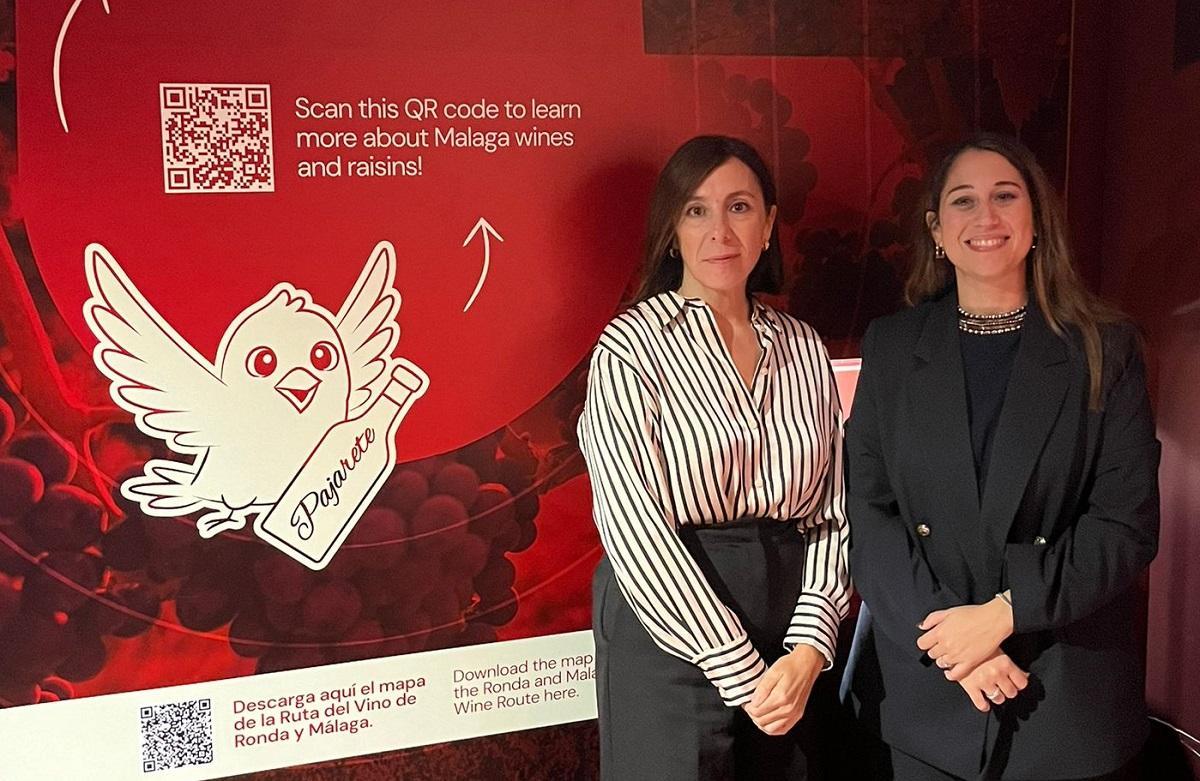 Vanessa Robles, directora del Museo del Vino de Málaga, y Noemi Carbonero, CEO de Rebeldía Tech, junto a la imagen de 'Pajarete', el asistente de IA..