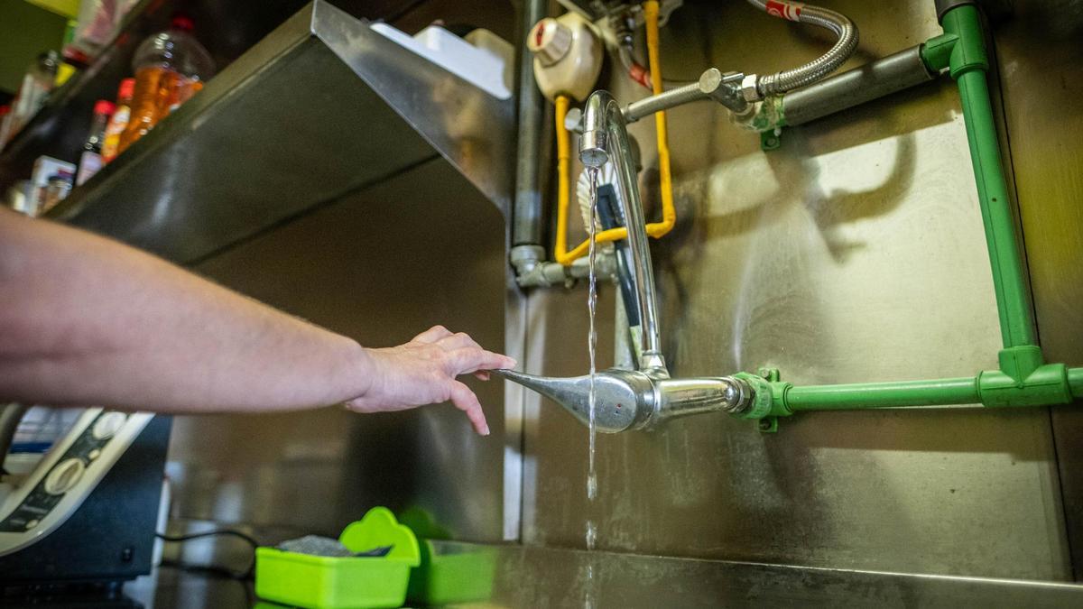 Raquel muestra el caudal de agua doméstica que le llega hasta el establecimiento, el Bar Susana.