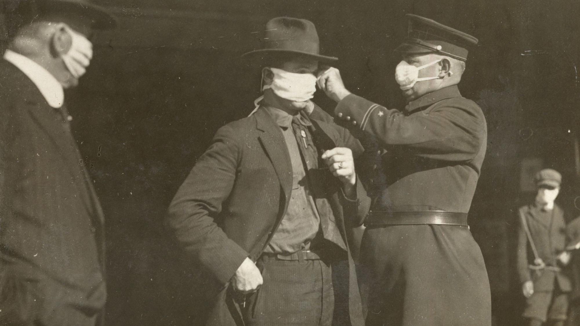 Un policía ajusta la mascarilla a un hombre durante la epidemia de gripe de 1918, en San Francisco