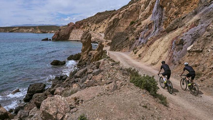 Dos ciclistas realizan un tramo en bicicleta por Mazarrón.