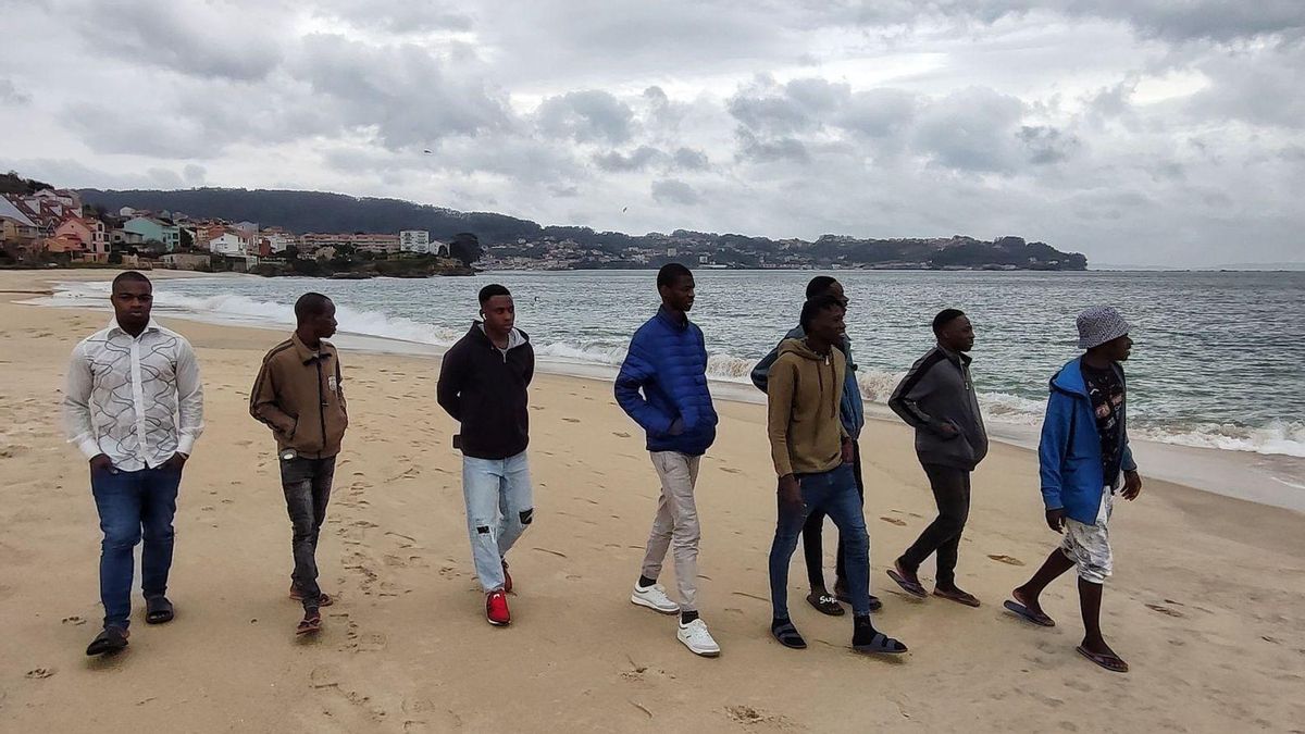 Varios de los inmigrantes subsaharianos, ayer, paseando por la playa de Agrelo.