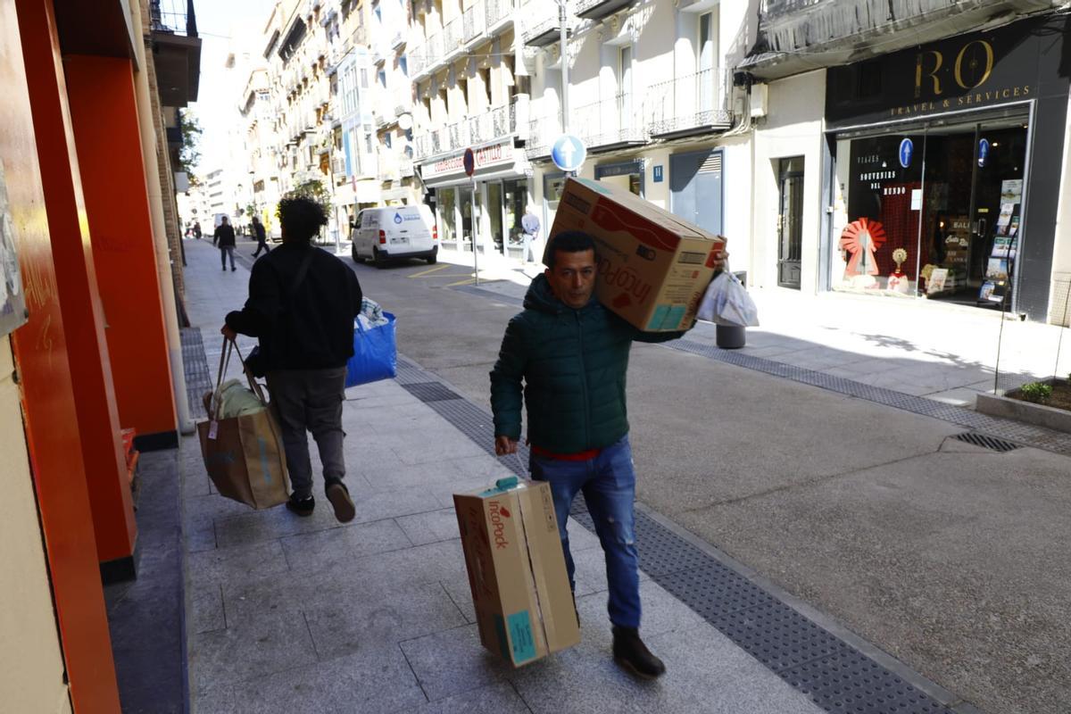 Un repartidor cargando bultos a pie.