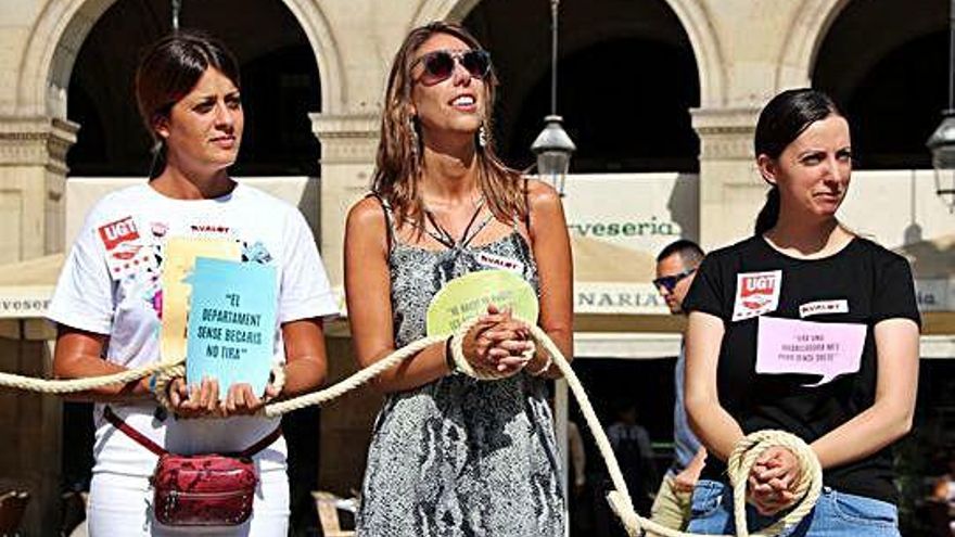 Tres joves lligades de mans en una «venda d'esclaus» simbòlica a plaça Reial per denunciar el treball precari